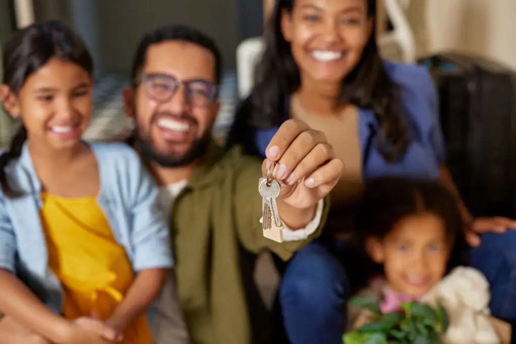 Smiling family holding up the keys to their new home