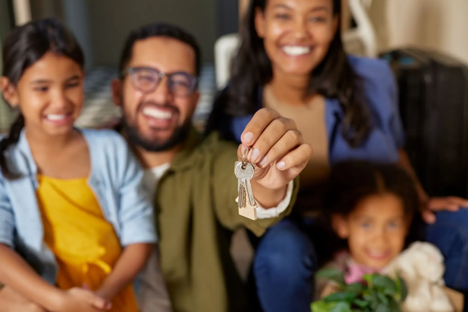 Smiling family holding up the keys to their new home